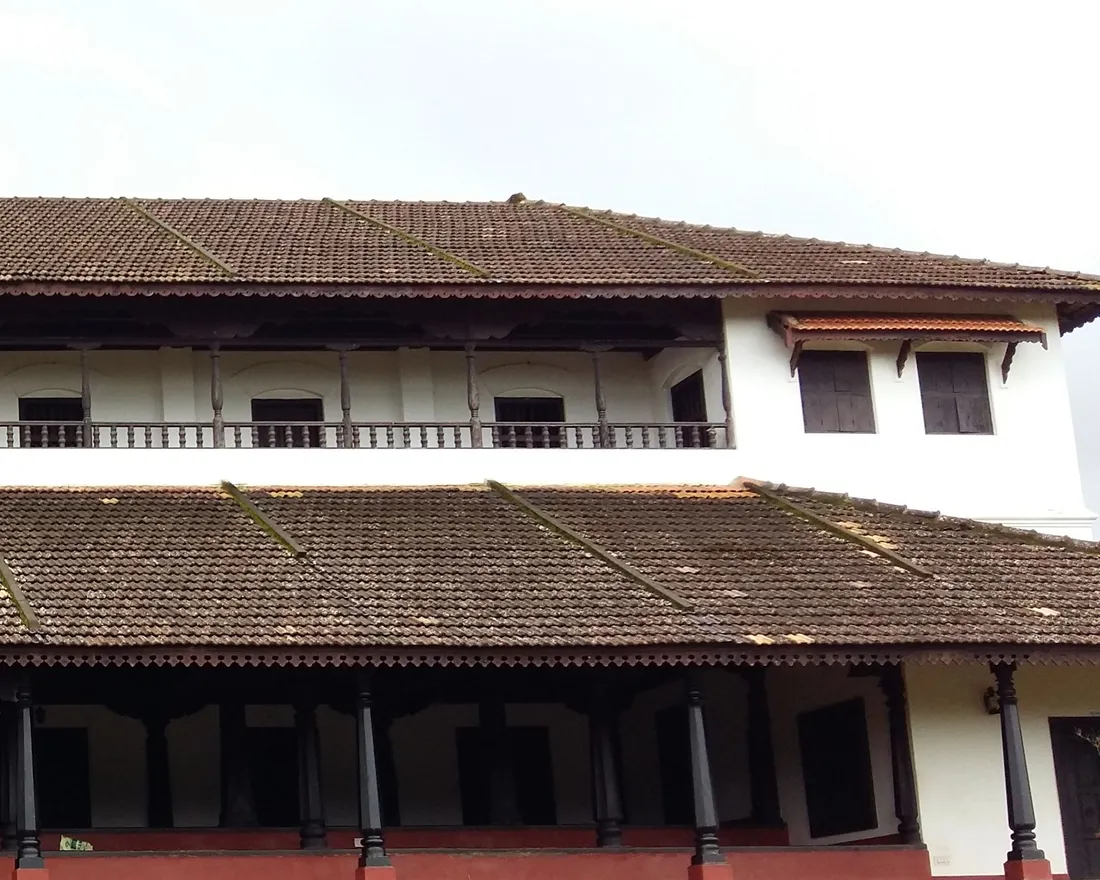 The carved wooden pillars, tiled roofs and balustraded verandah of a traditional Bunt guttu mane, the ancestral house of a Tuluva family in coastal Karnataka