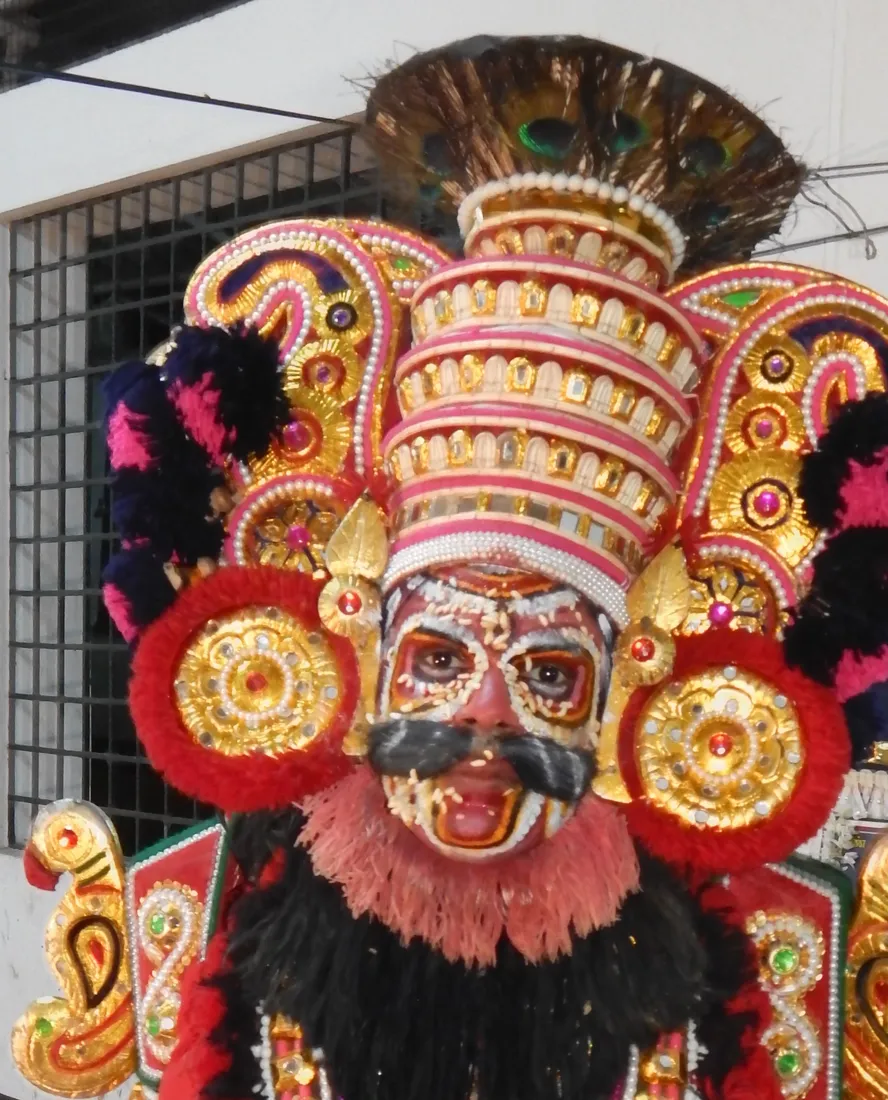 A Yakshagana artist in the full Thenkuthittu headdress and traditional face make-up of the night-long dance theatre of Tulu Nadu, carried forward by Bunt families of coastal Karnataka