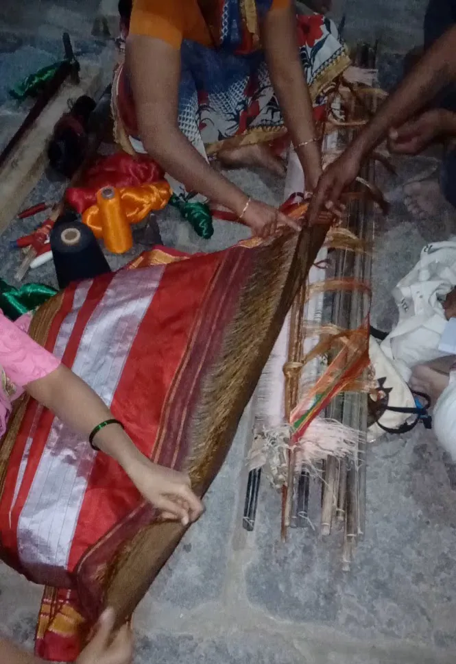 A traditional handloom in North Karnataka with the shuttle and coloured warp threads at work — the craft heritage from which Devanga families have risen into every walk of life