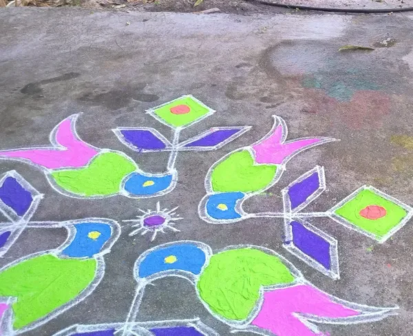 A Sankranti muggu drawn in bright colour on the open ground during the Telugu harvest festival