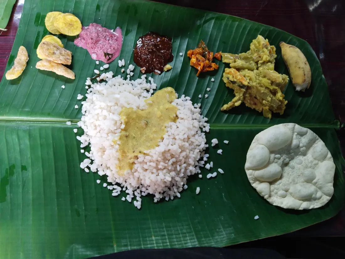 An Onam sadya served on a banana leaf with rice, avial, pachadi, banana chips and papadam, the vegetarian feast Kerala families share